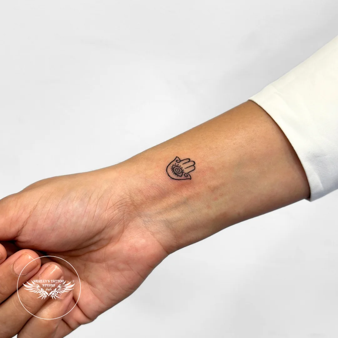 Small hamsa symbol tattoo on a wrist
