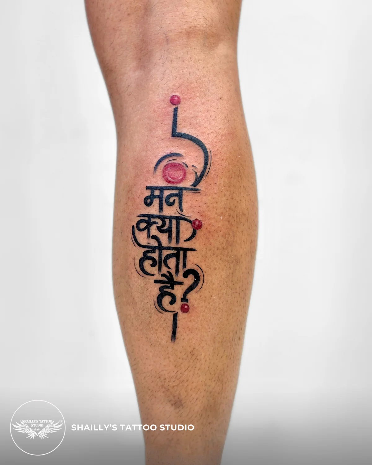 Colour-accented Hindi lettering tattoo on a lower leg